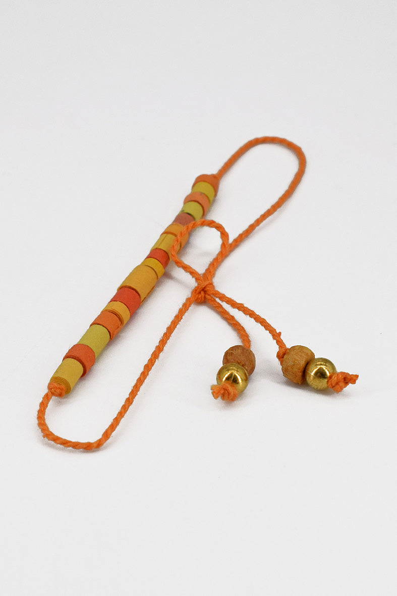 Paper trimmed tonal beads rakhi with tassel